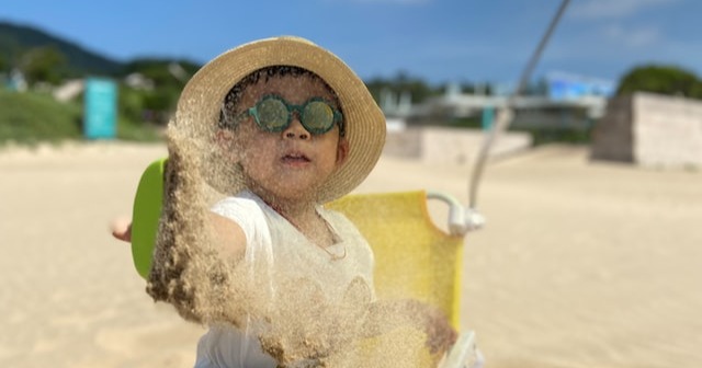 Child throwing sand on the beach